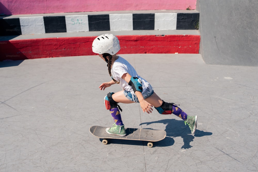 uma jovem montando um skate em uma superfície de cimento