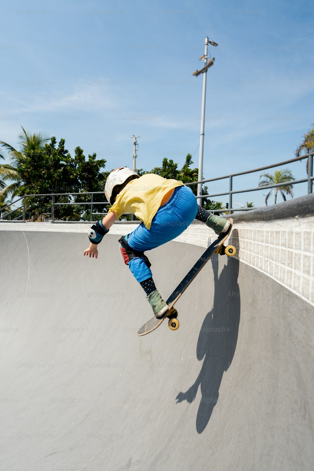 スロープの脇をスケートボードで登る男性