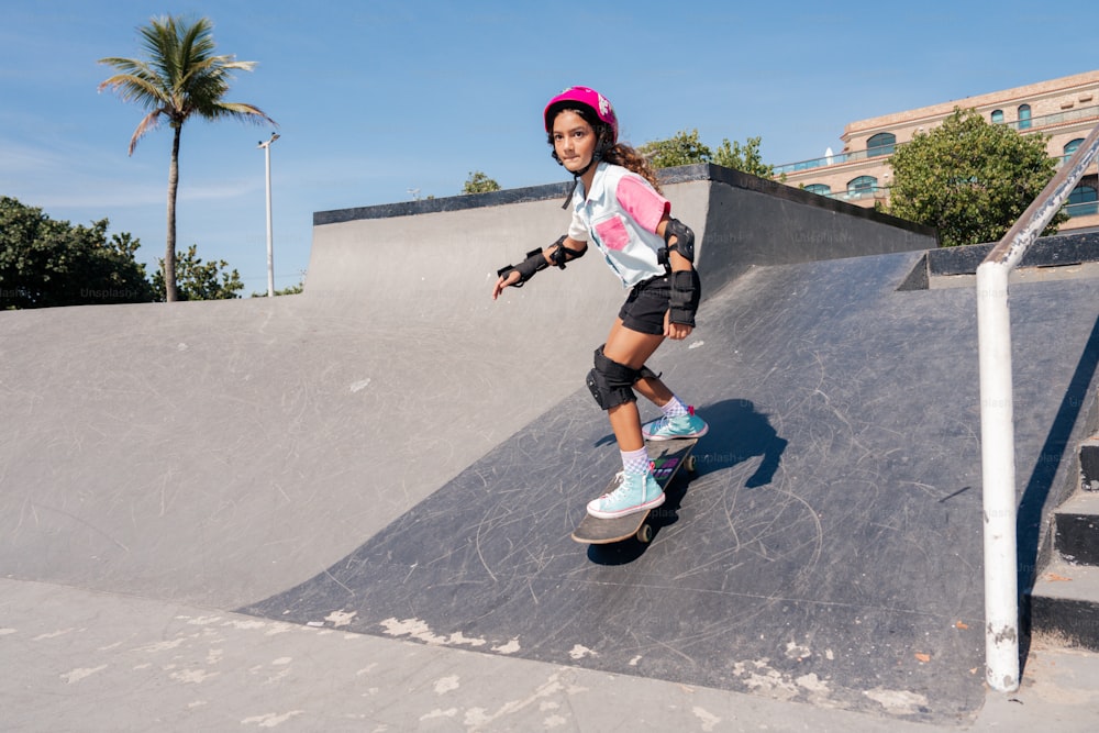 a young girl riding a skateboard up the side of a ramp