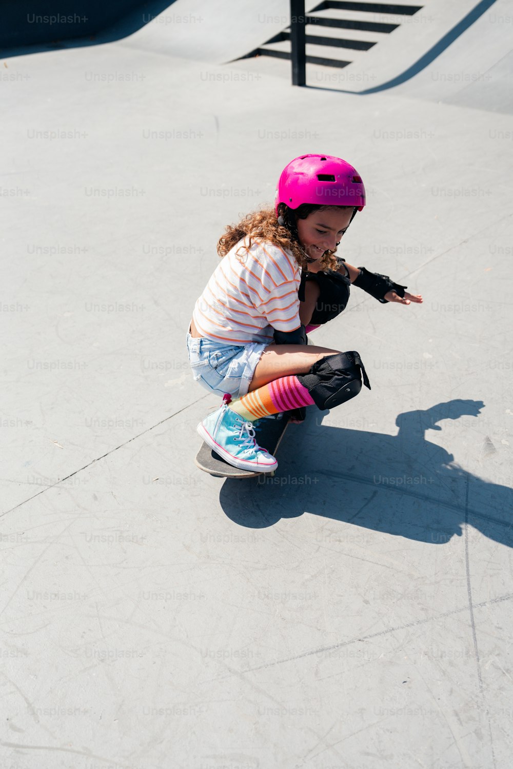 경사로를 따라 스케이트보드를 타고 내려가는 어린 소녀
