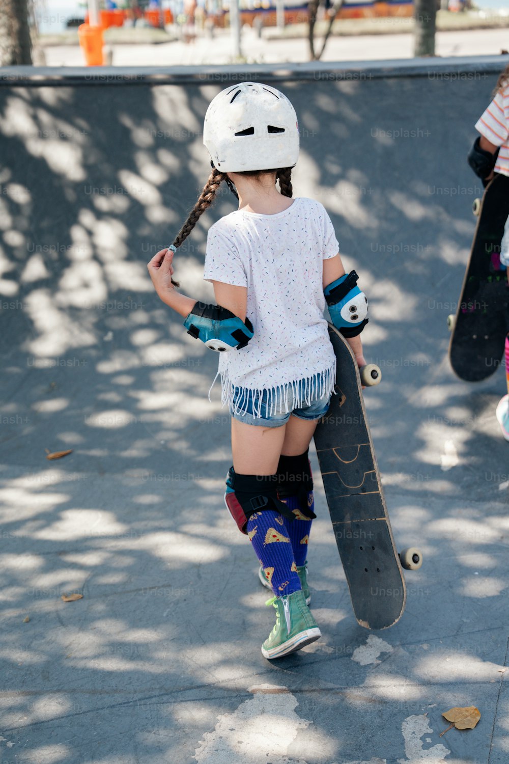 a little girl holding a skateboard in her hands