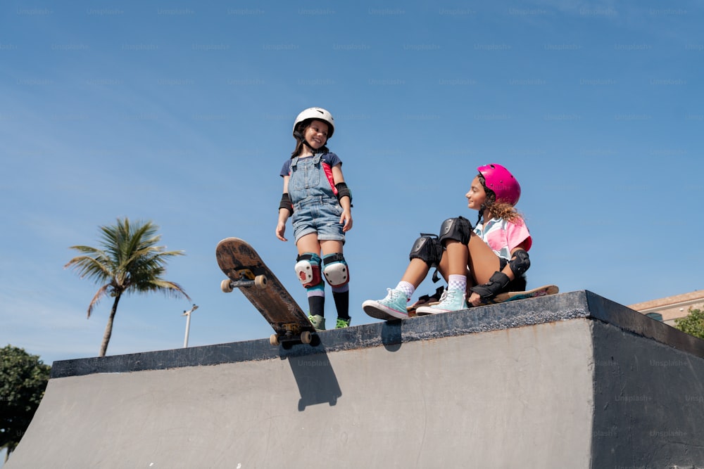 Ein paar Kinder sitzen auf einer Skateboard-Rampe