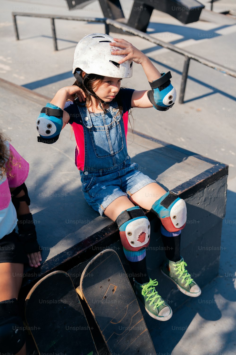 a little girl sitting on top of a skateboard ramp