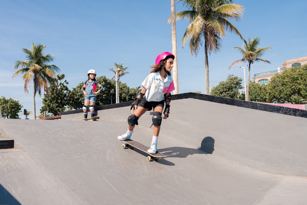 a young girl riding a skateboard down a ramp