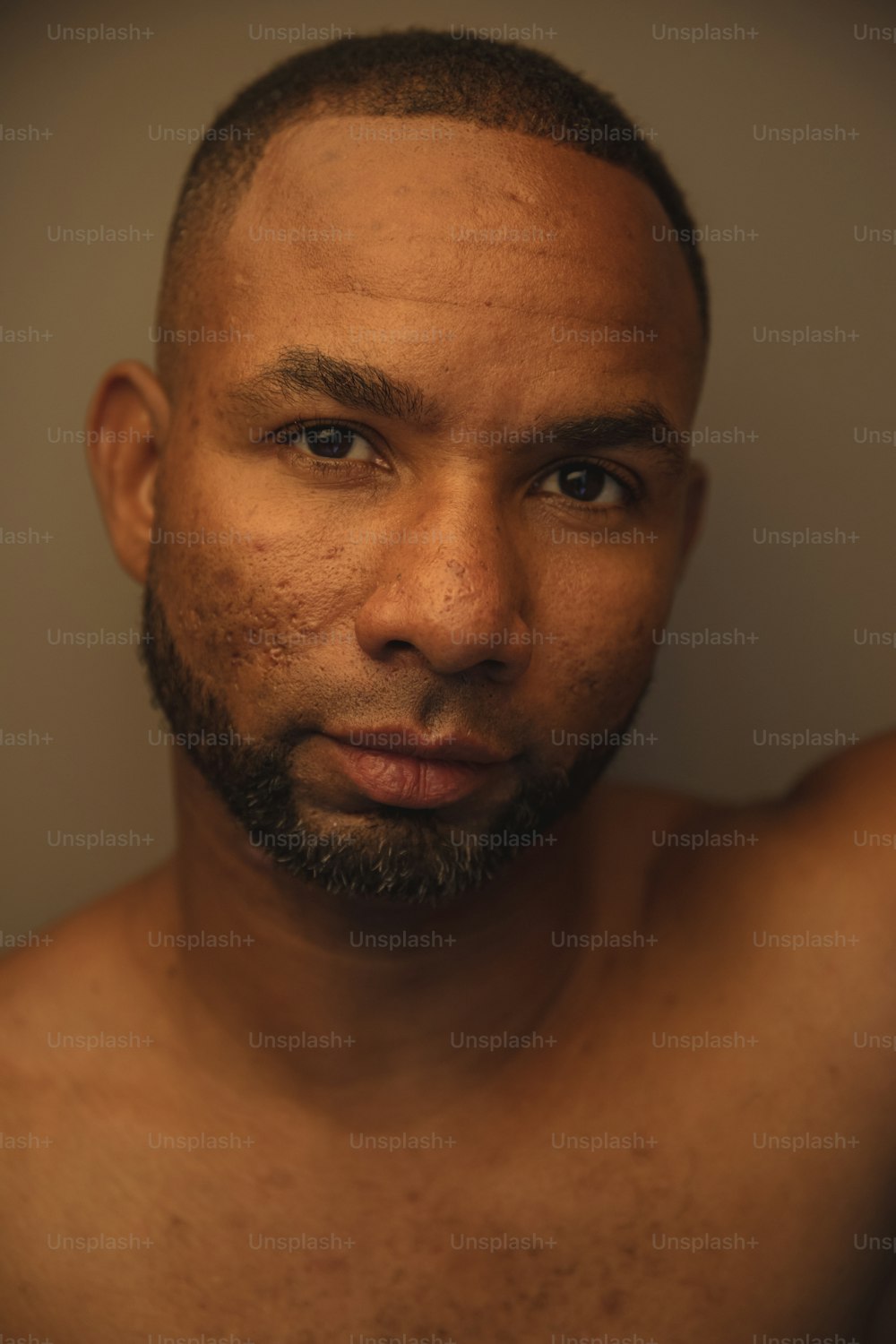 a close up of a shirtless man with a beard