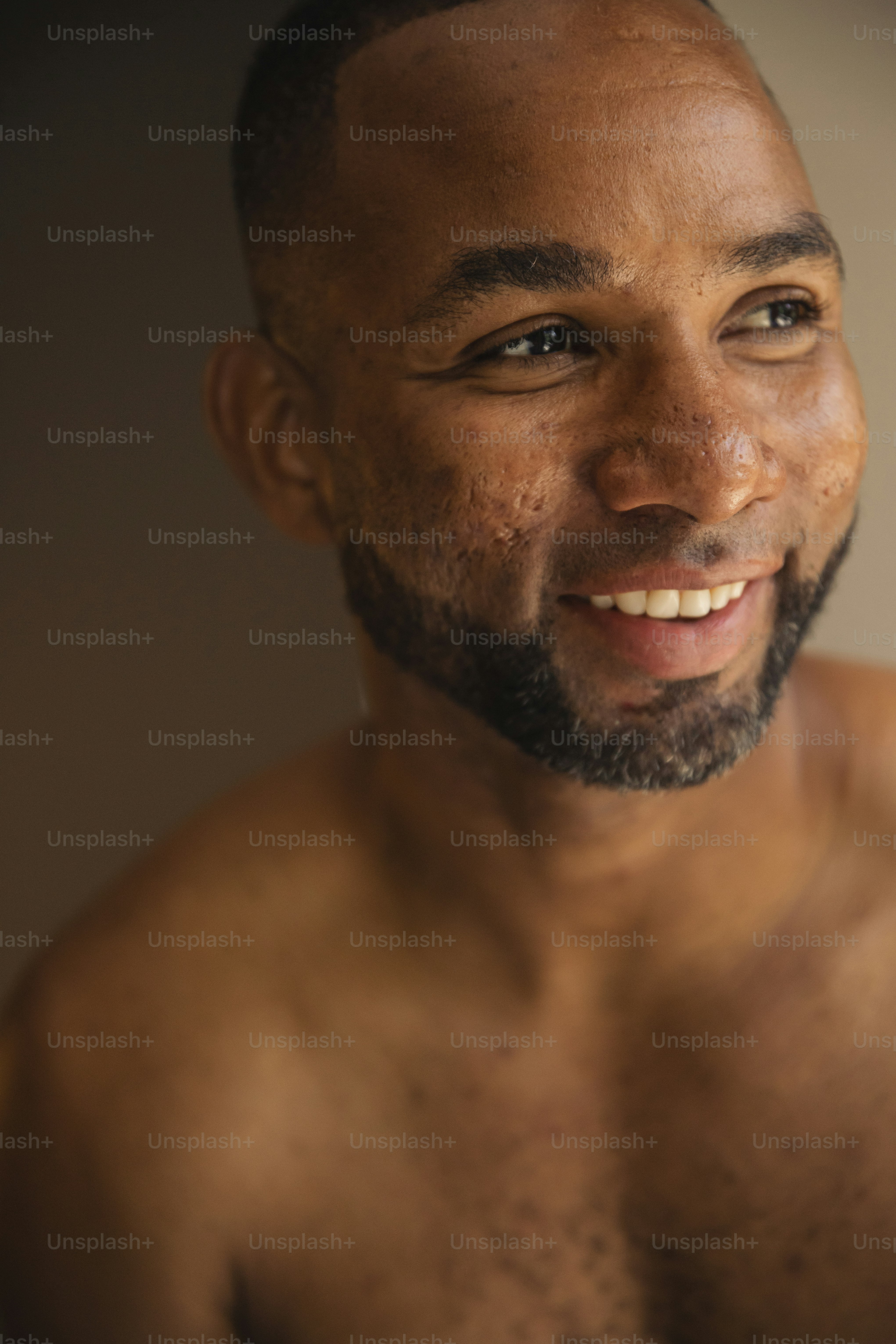 Un hombre sin camisa sonriendo para la cámara