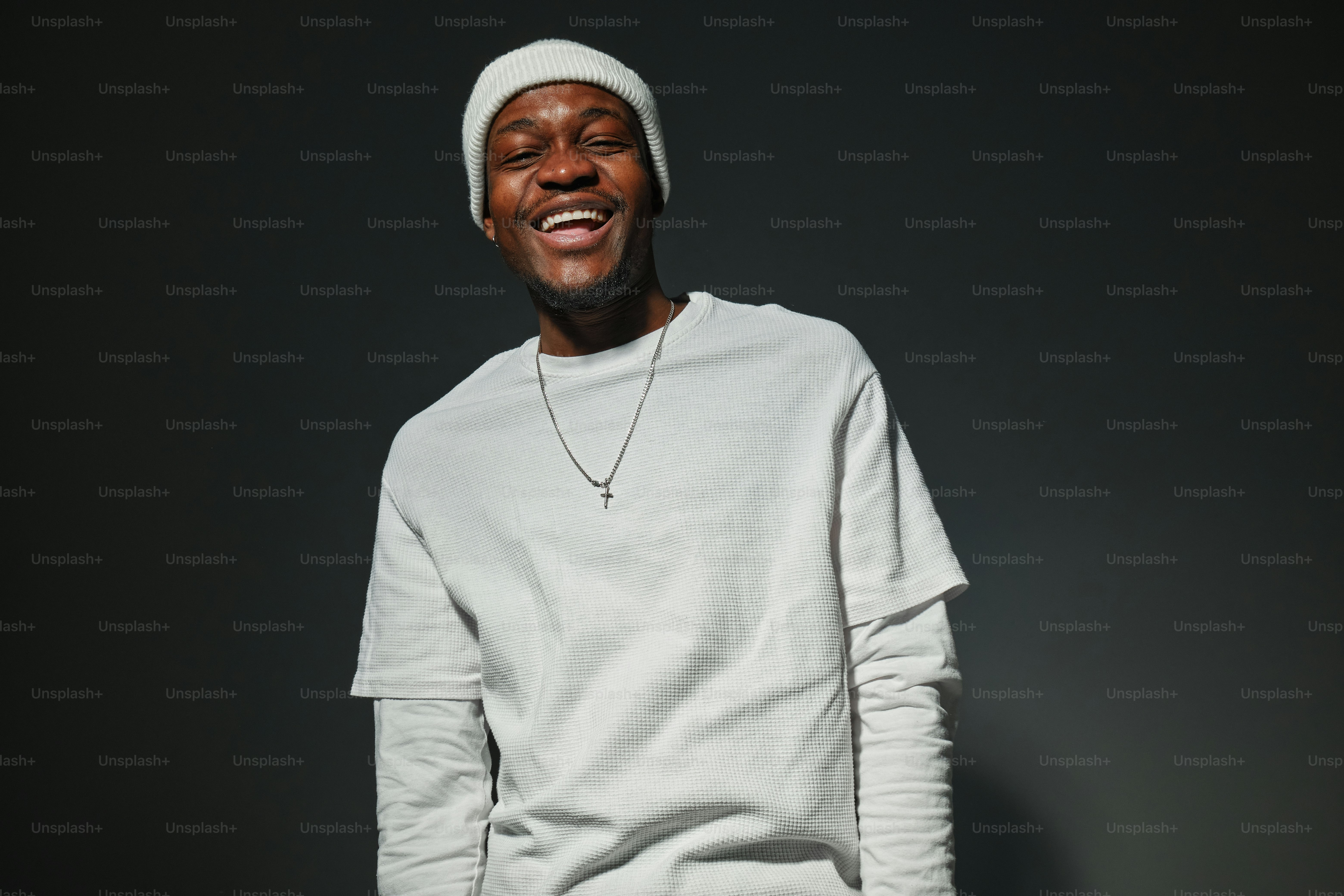 a smiling man in a white shirt and hat