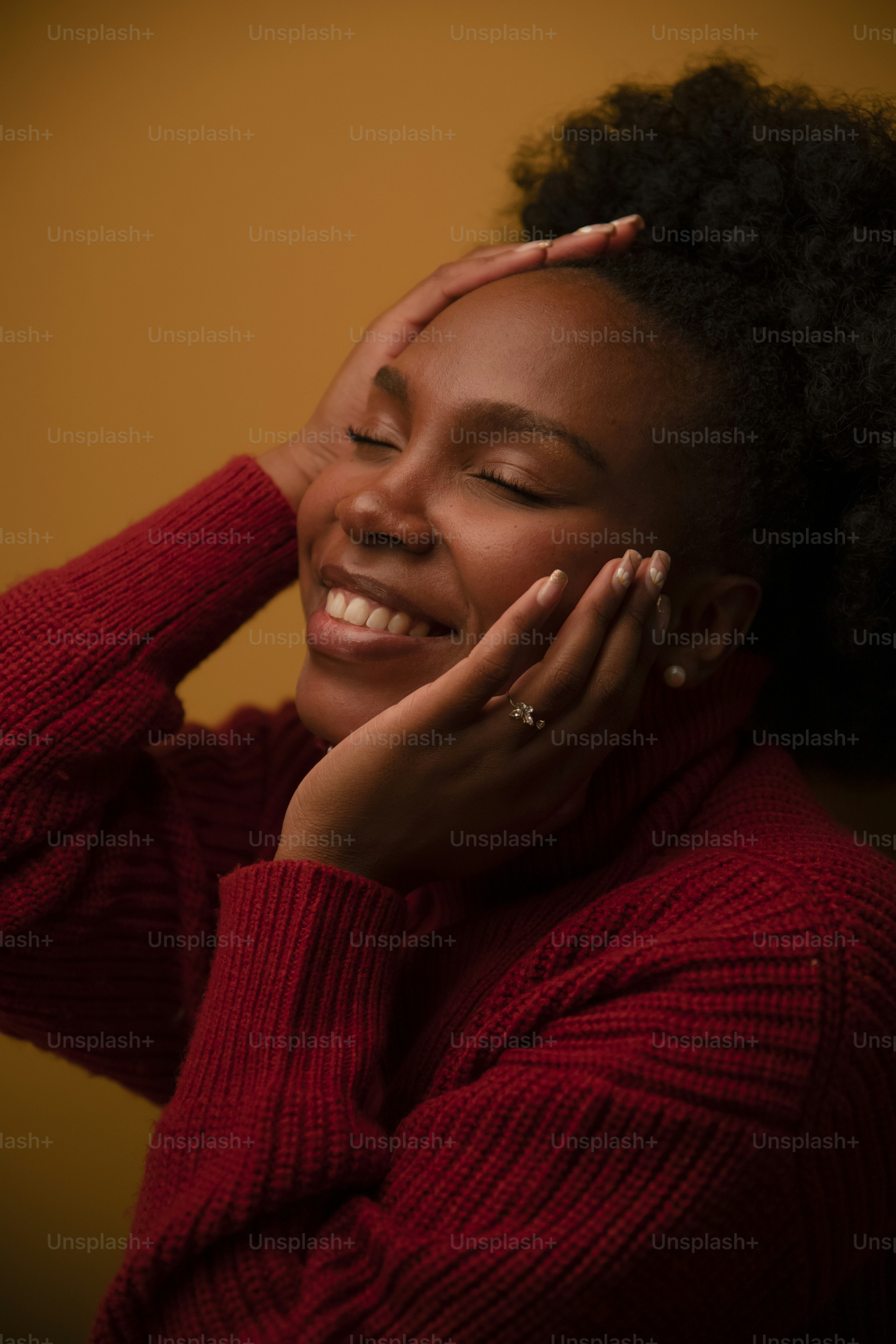 a woman smiling with her hands on her face