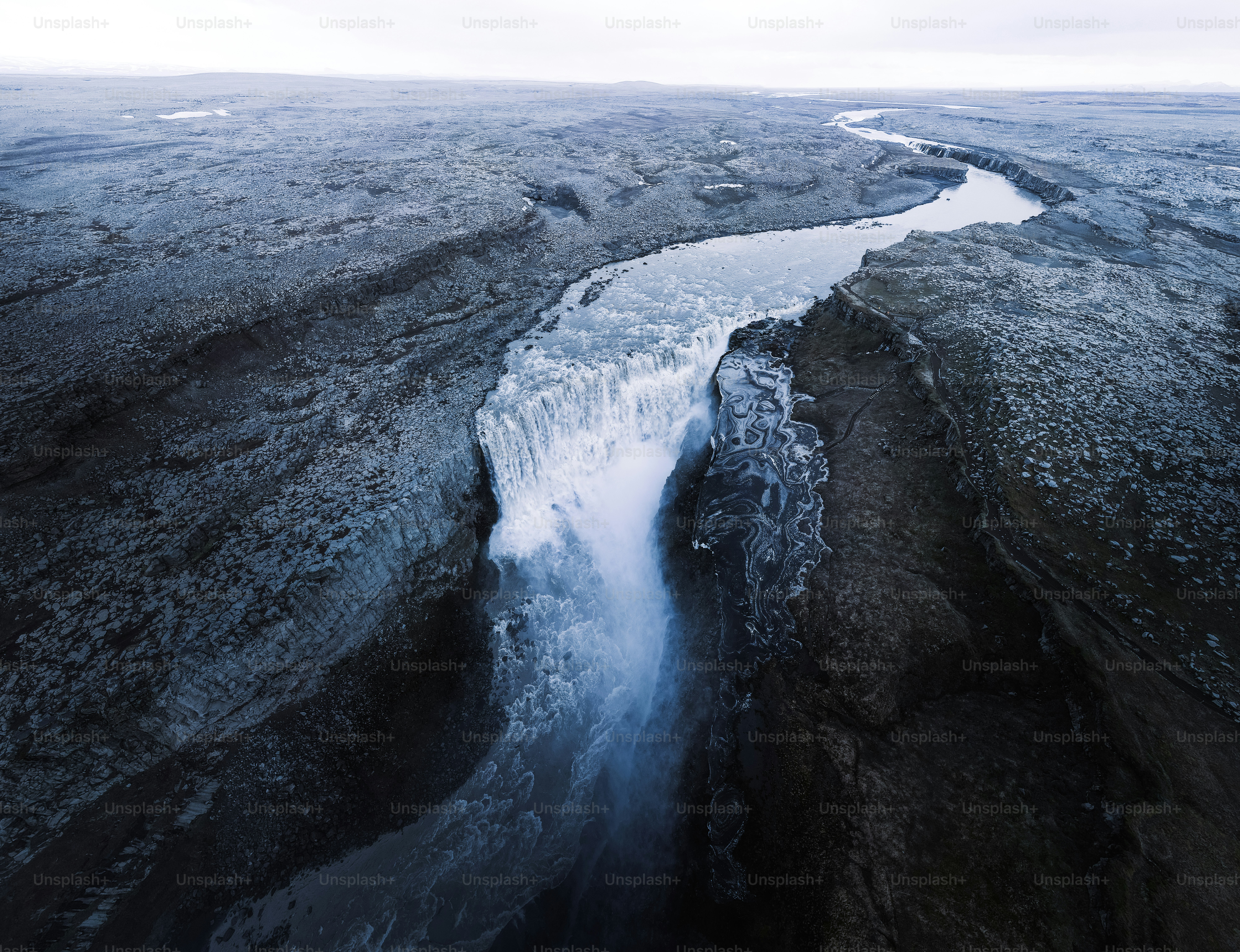 an aerial view of a river running through a rocky landscape
