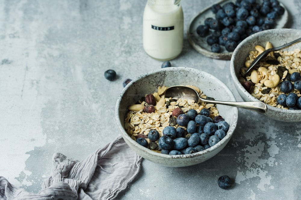 a couple of bowls filled with blueberries and granola