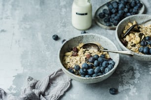 a couple of bowls filled with blueberries and granola