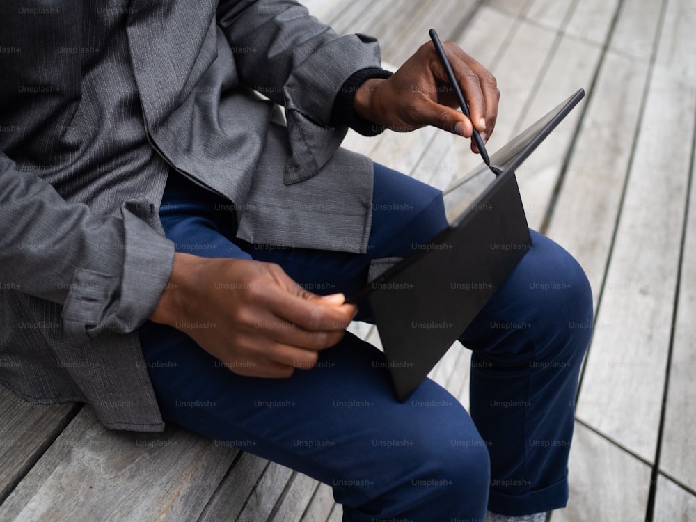 une personne assise sur un banc avec un ordinateur portable