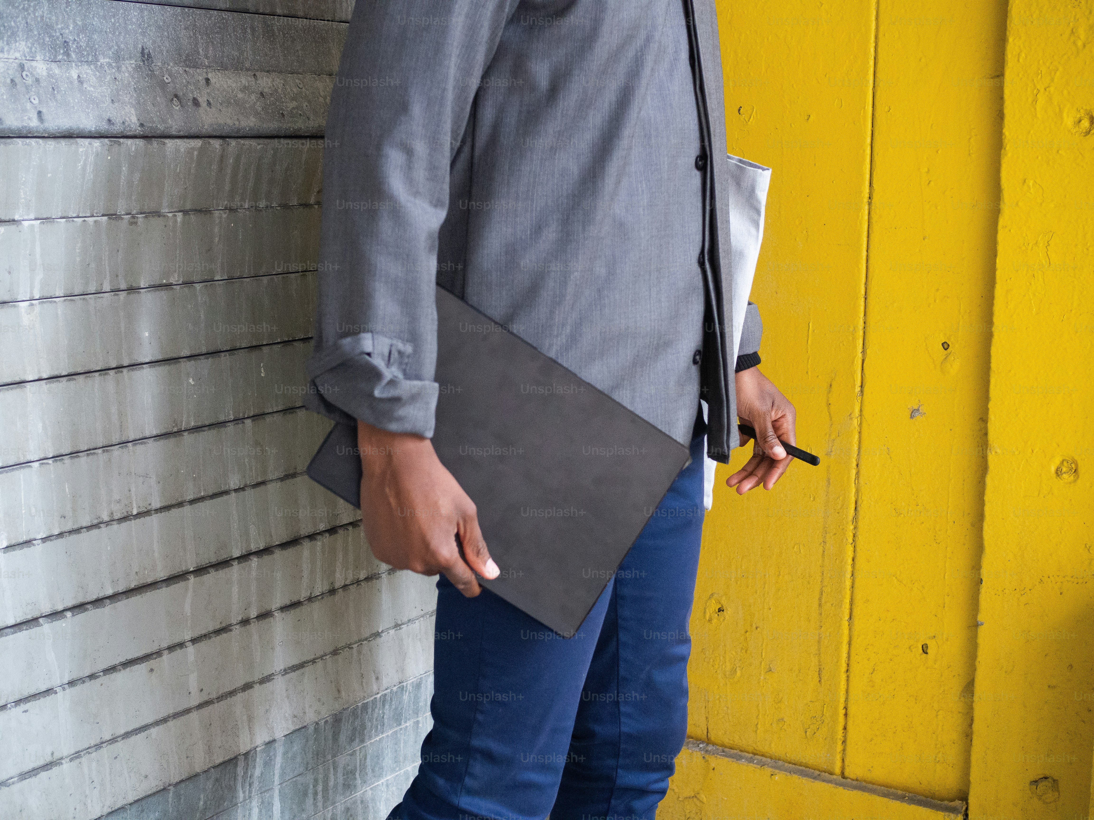 Un hombre de pie junto a una pared amarilla