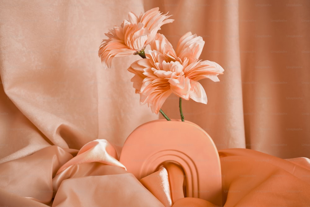 a vase with a flower in it sitting on a bed