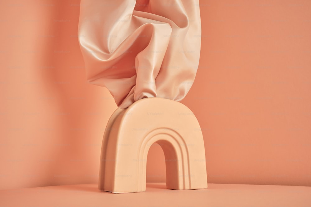 eine Skulptur eines weißen Bogens, über den ein rosafarbenes Tuch drapiert ist