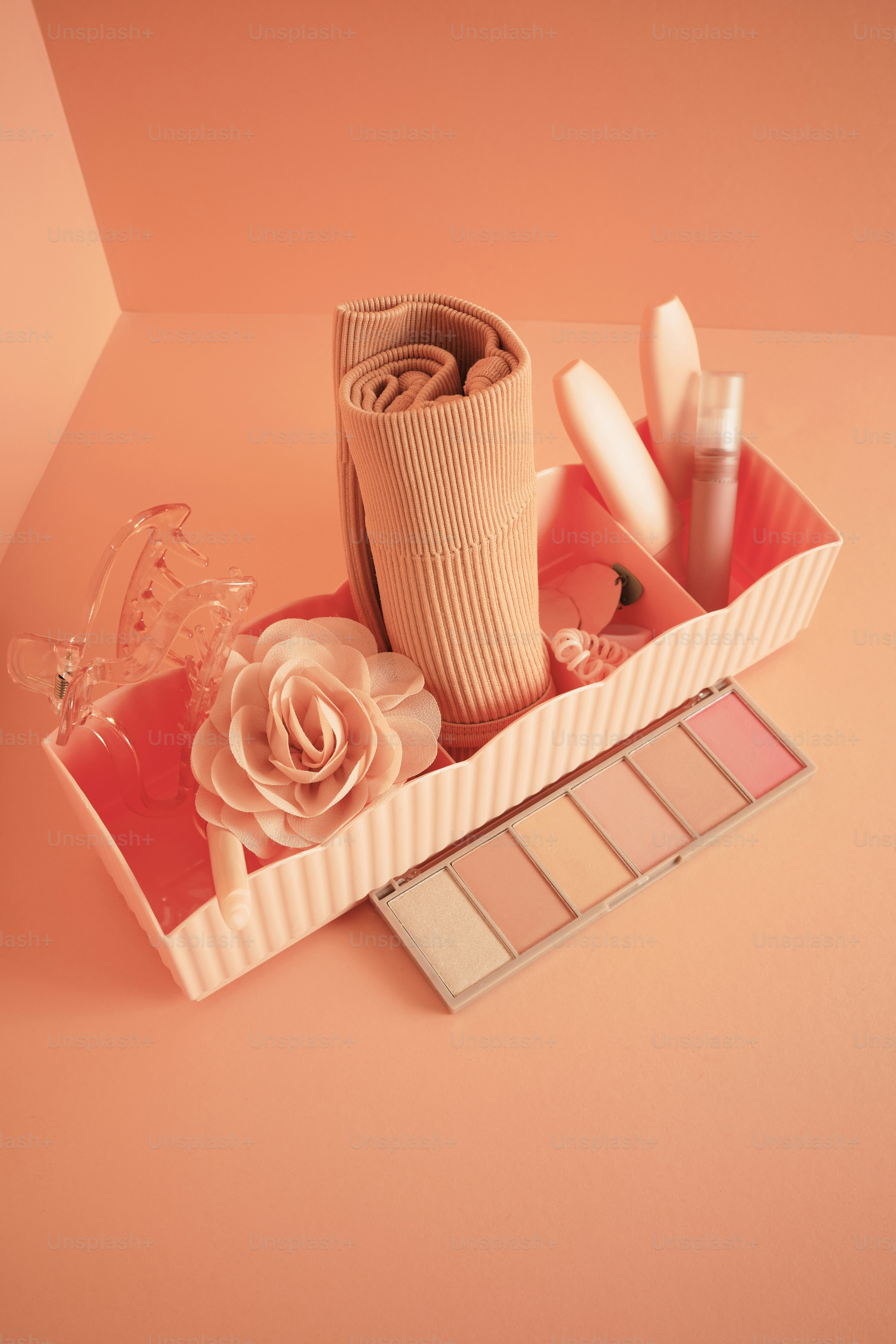 a pink box filled with makeup and other items