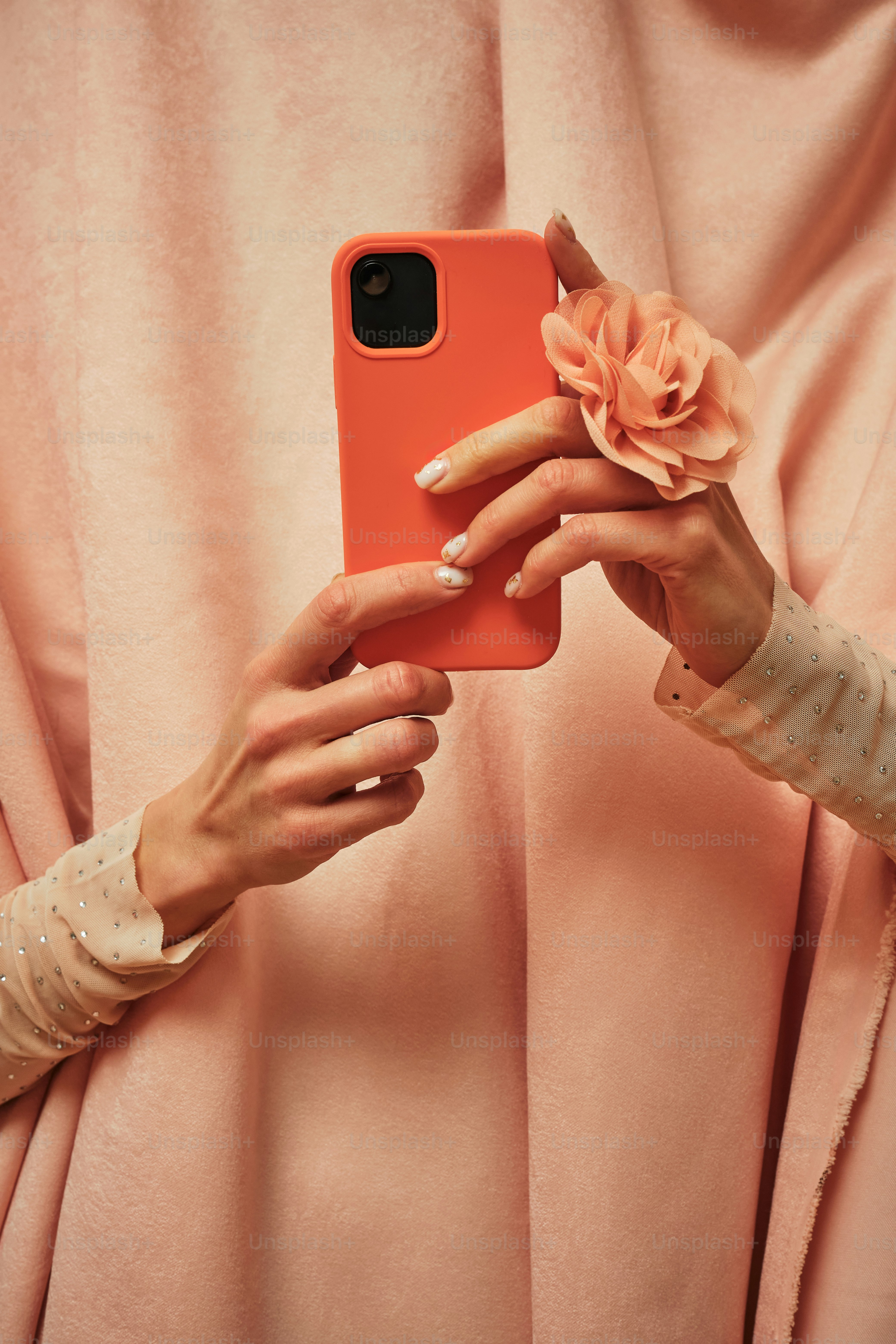 a woman holding a cell phone with a flower in her hand
