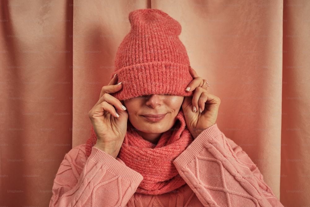 a woman wearing a pink hat and scarf