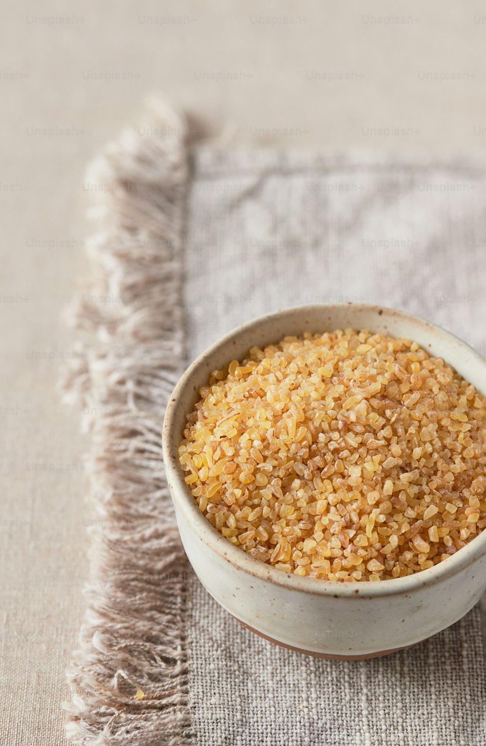 a white bowl filled with brown rice on top of a table