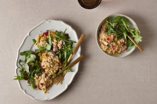 two plates of food with chopsticks on a table