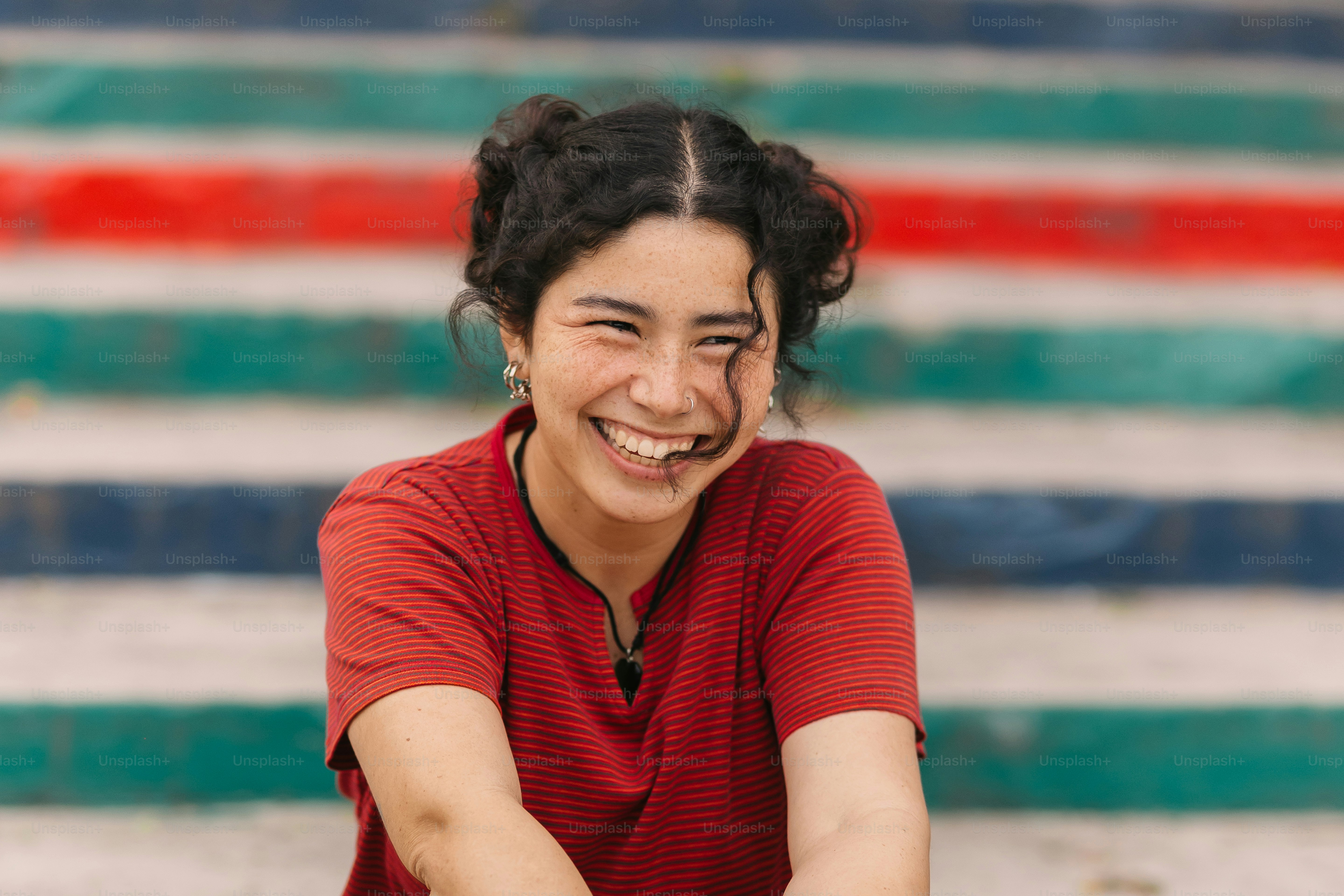 a woman sitting on the ground smiling for the camera