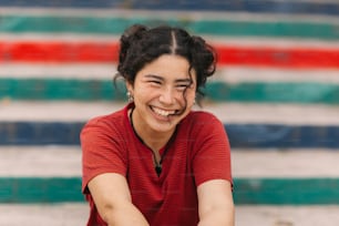 a woman sitting on the ground smiling for the camera