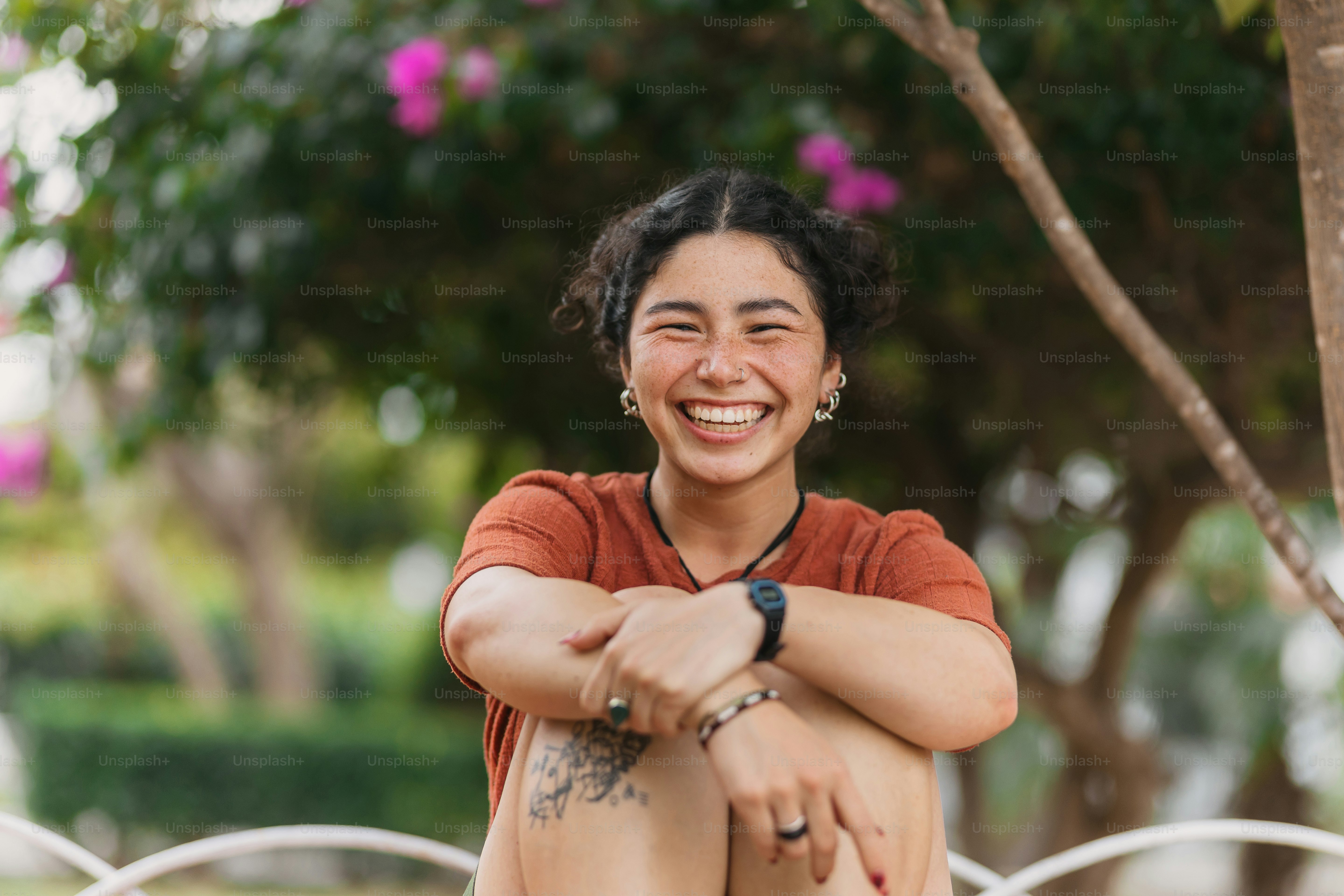 A smiling woman sitting on a bench in a park photo – Beauty Image on ...