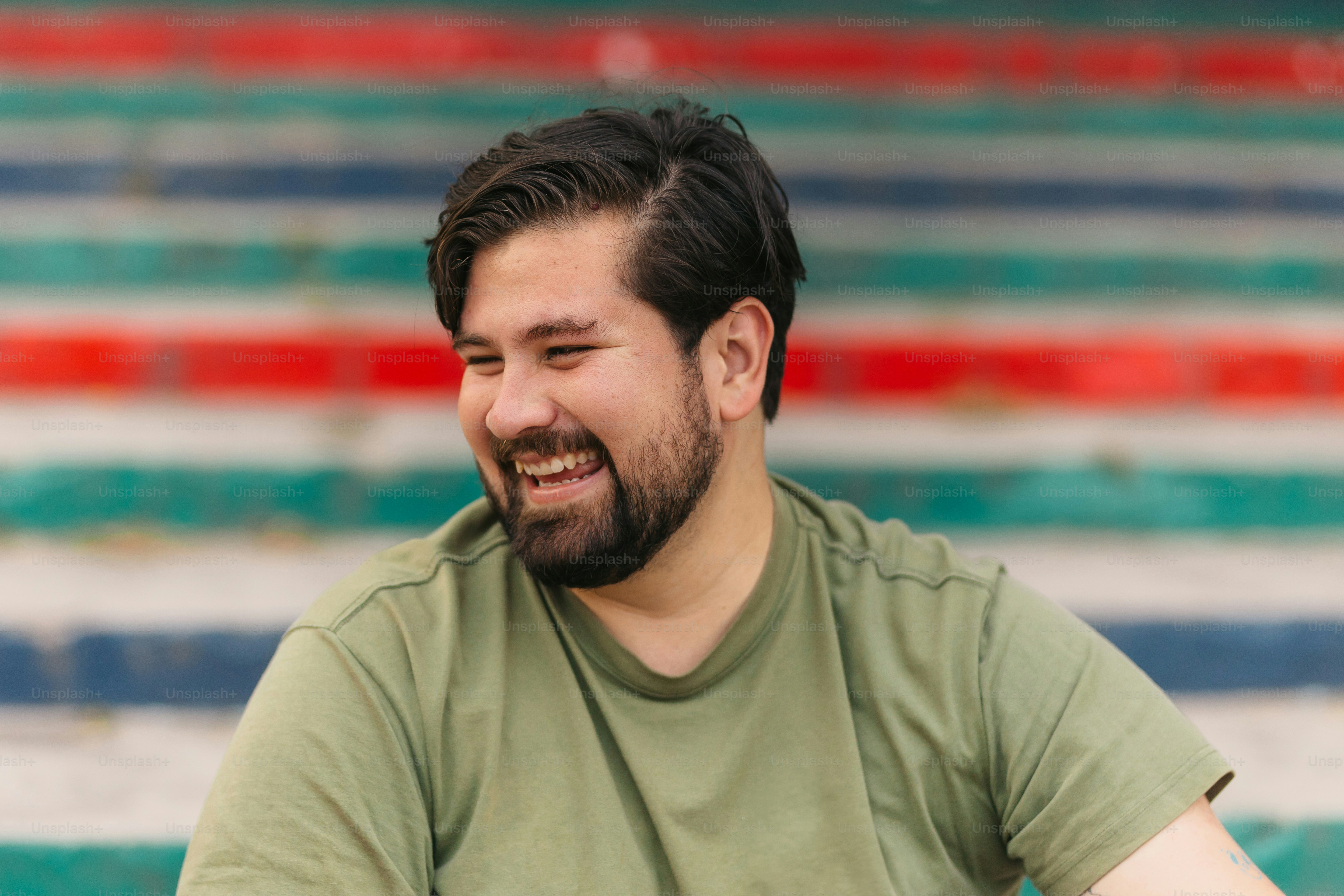 a man with a beard smiles while sitting down
