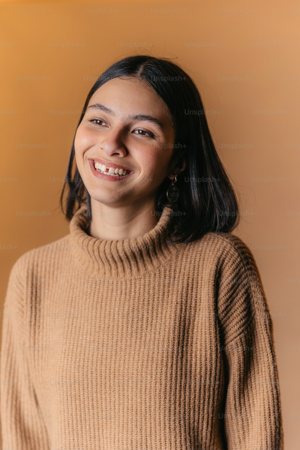 a smiling woman in a brown sweater