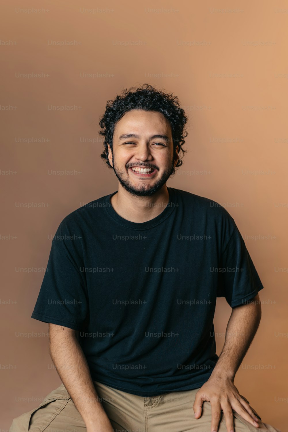 a man with curly hair and a black shirt