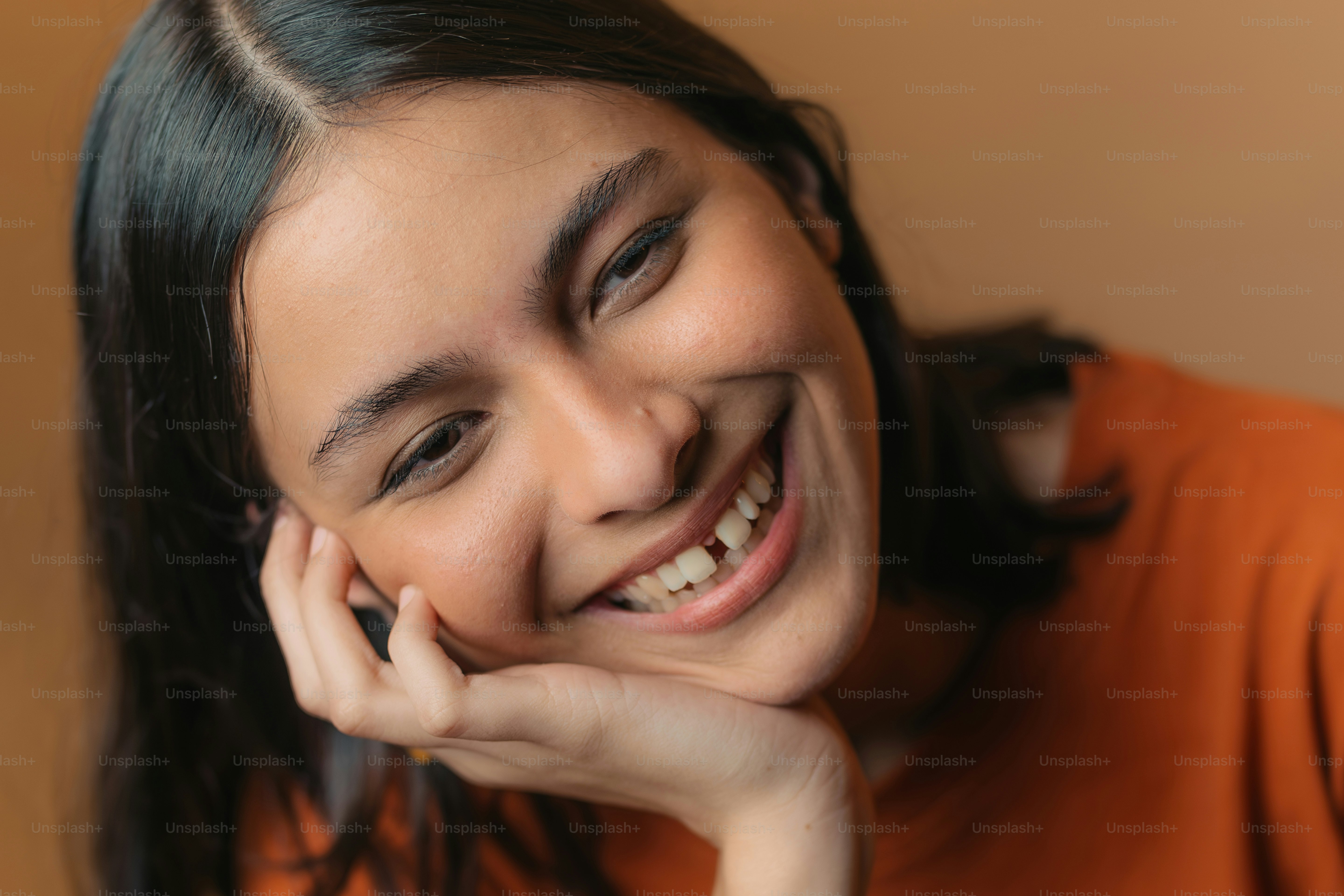 a woman smiling with her hand on her chin