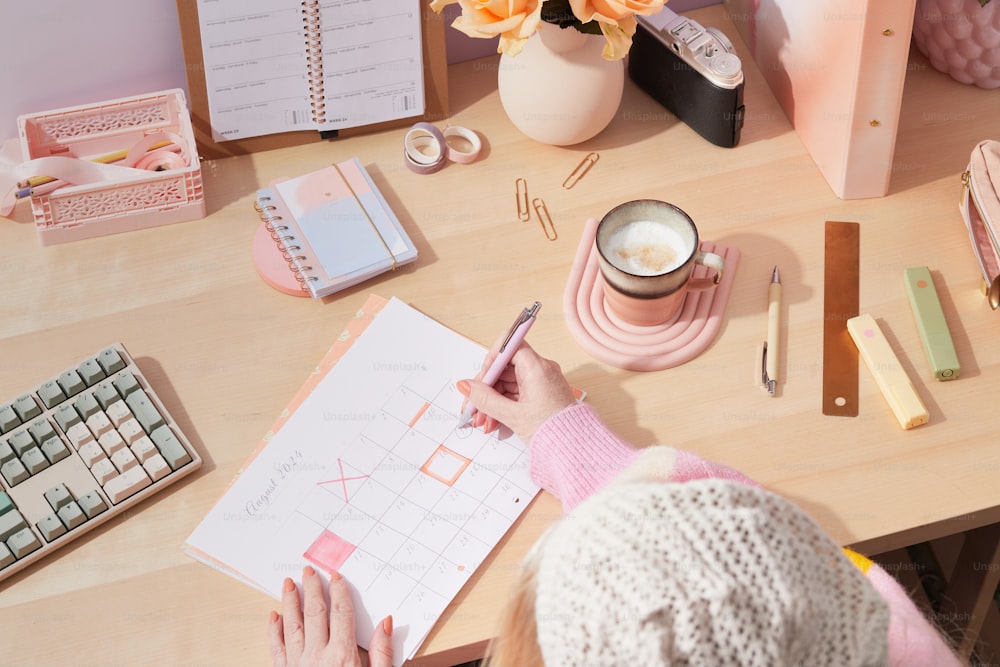 a woman sitting at a desk working on a piece of paper