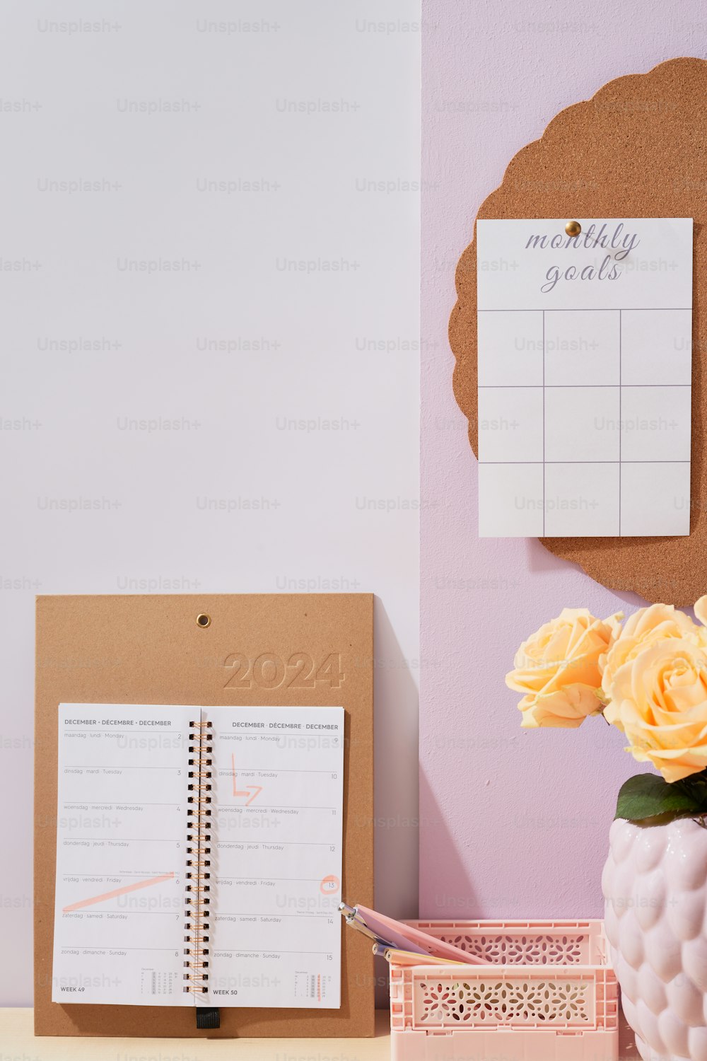uma escrivaninha com bloco de notas, caneta e um vaso de flores