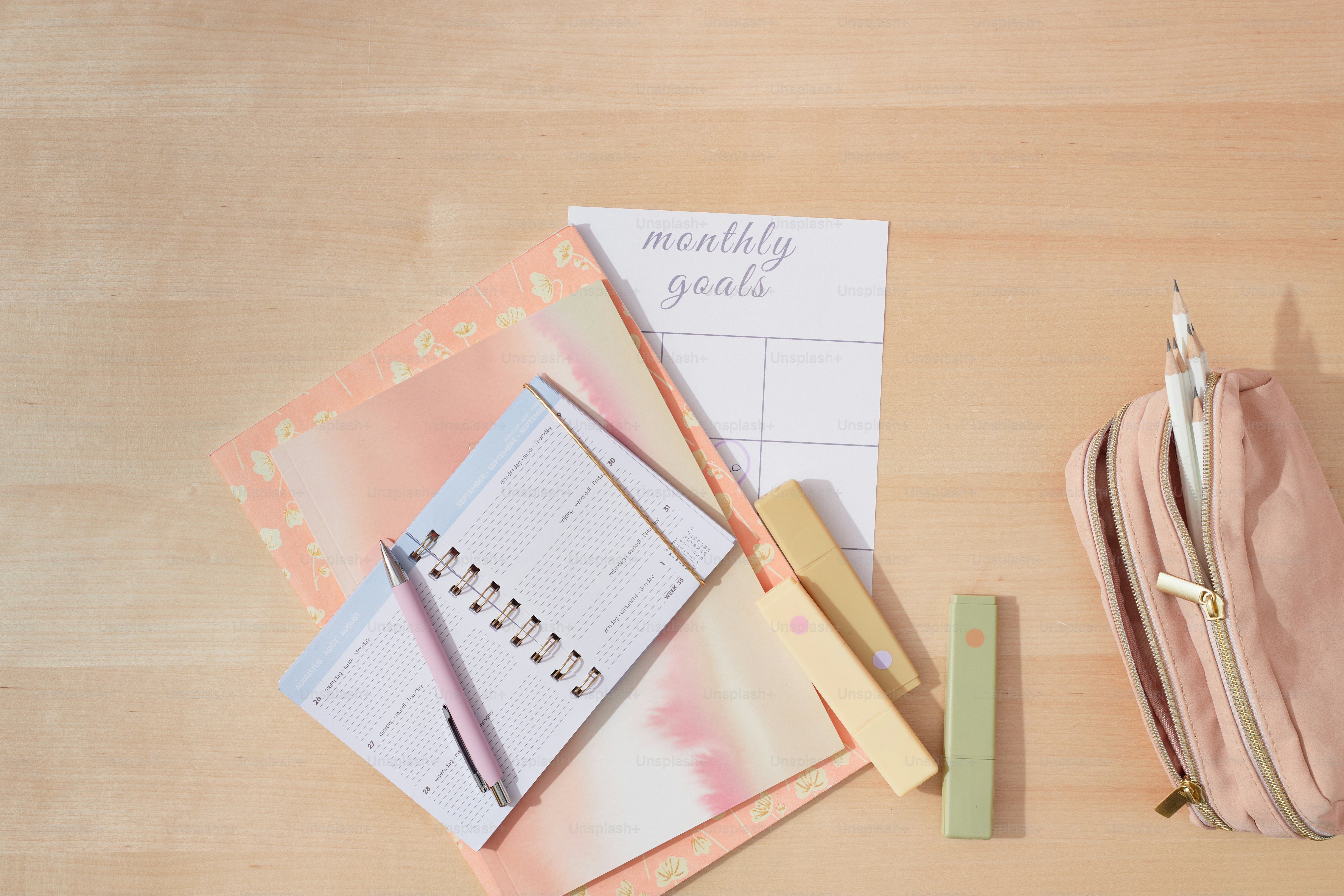 a wooden table topped with a pink bag and a calendar