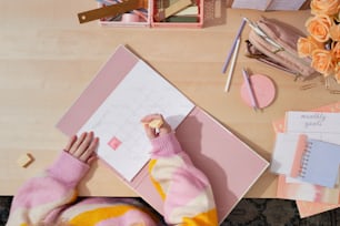 a person writing on a calendar on a desk