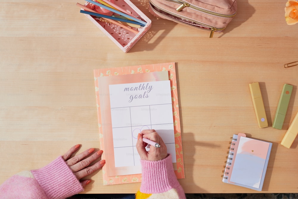 una persona escribiendo en un calendario sobre una mesa