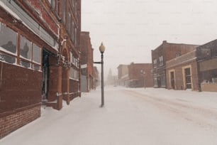 a street light on a snowy street in a small town