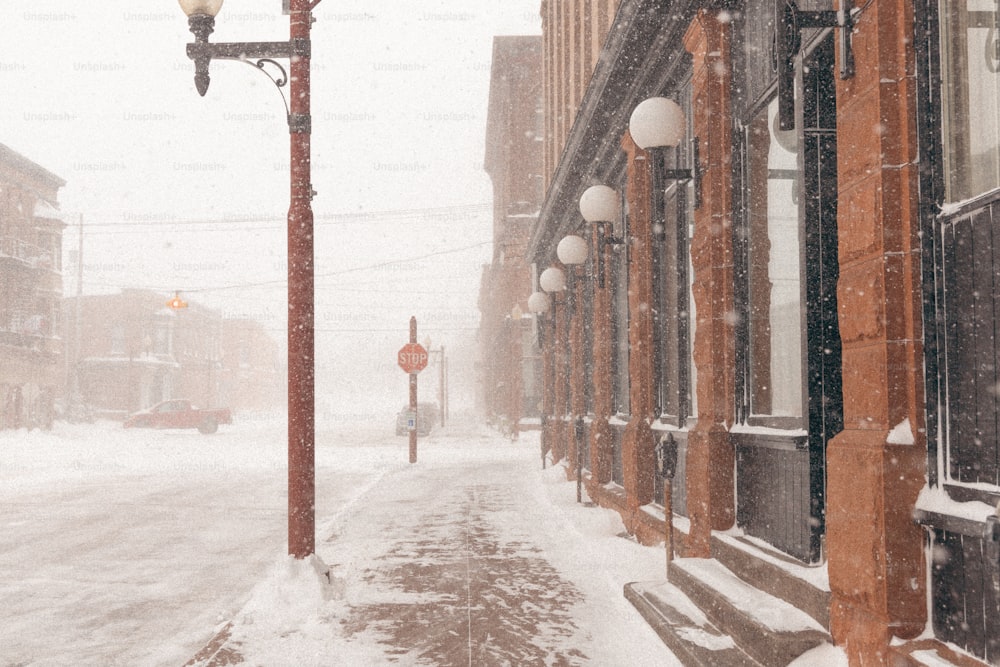 una farola en una calle nevada con edificios en el fondo