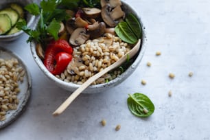 un bol lleno de arroz y verduras junto a una cuchara