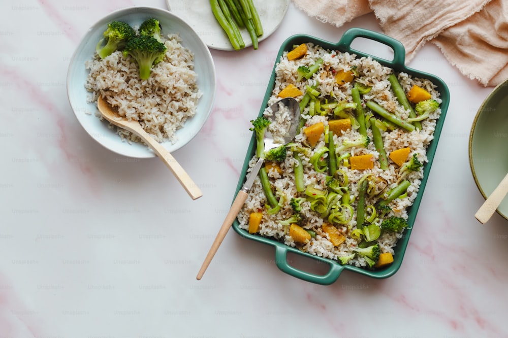 a dish of rice, broccoli, and carrots on a table