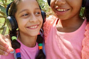 two girls wearing headphones and smiling for the camera