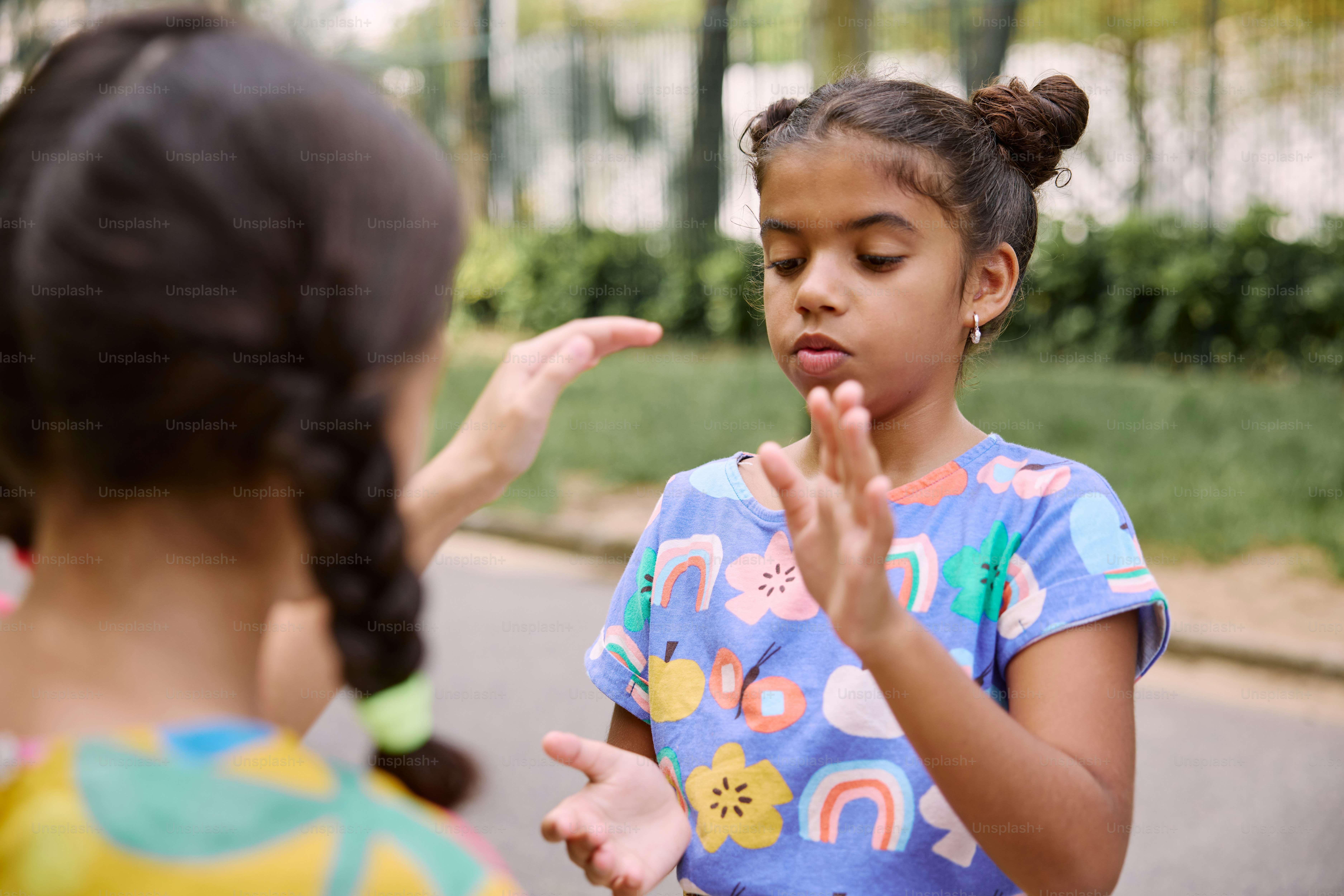 a little girl standing next to another little girl