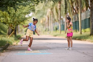 two young girls are playing on the street