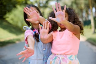 two young girls with their hands covered in paint