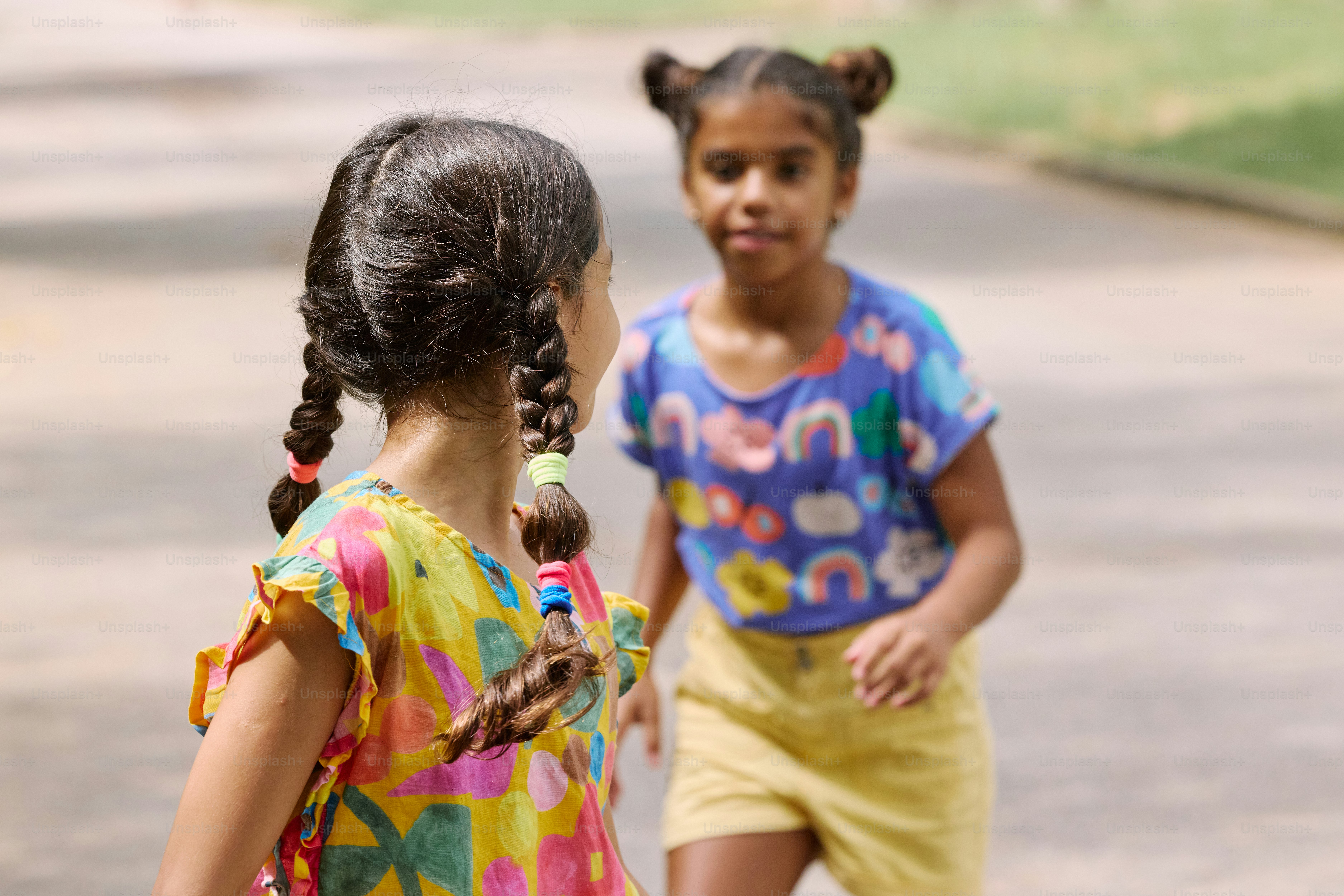 two young girls are playing with a frisbee