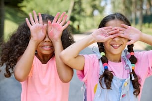 two little girls covering their eyes with their hands