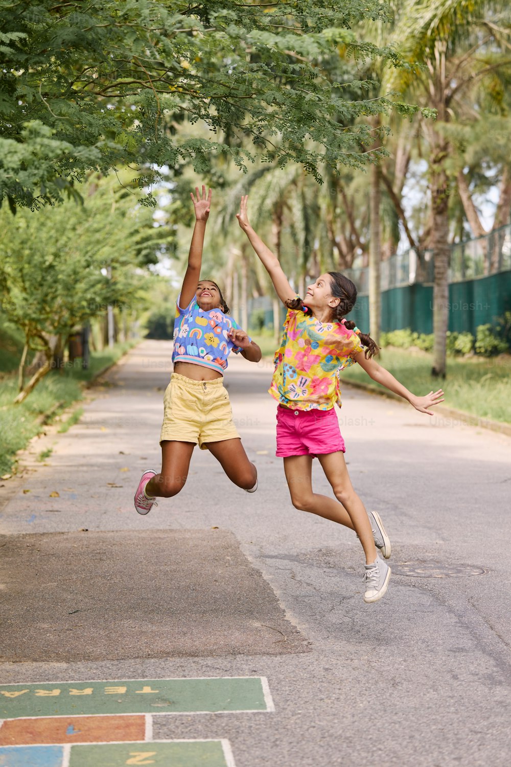 two young girls jumping up in the air