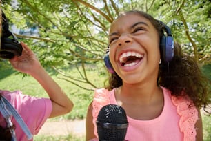 a young girl wearing headphones and singing into a microphone