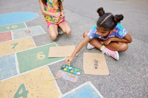 two young girls sitting on the ground playing with numbers