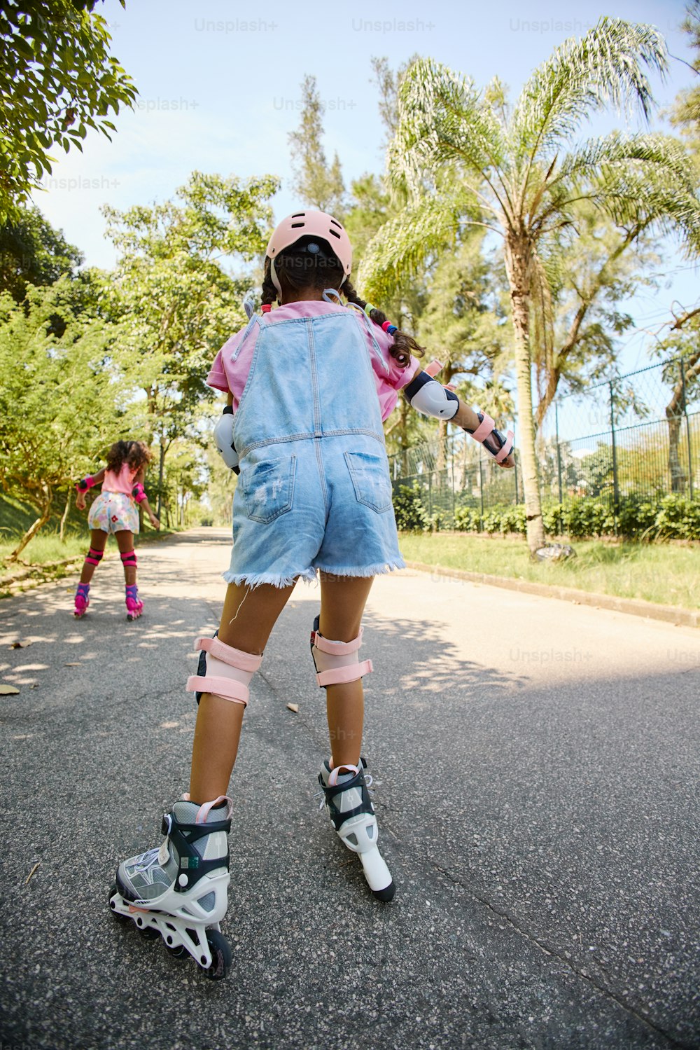 a young girl riding a skateboard down a street